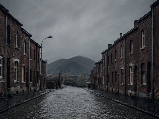 Une rue de maisons ouvrières en brique rouge, terril au fond